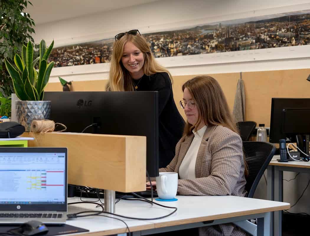Zwei Frauen arbeiten gemeinsam an einem Computer